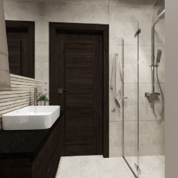 EF-KA Studio Design EWA WESOŁEK-PRZYCHODZKA - Nowoczesna łazienka z ciemnymi drewnianymi akcentami: szafka pod umywalką z czarnym blatem, biała umywalka nablatowa, lustro, ciemne drzwi, kabina prysznicowa z deszczownicą i biały ręcznik.