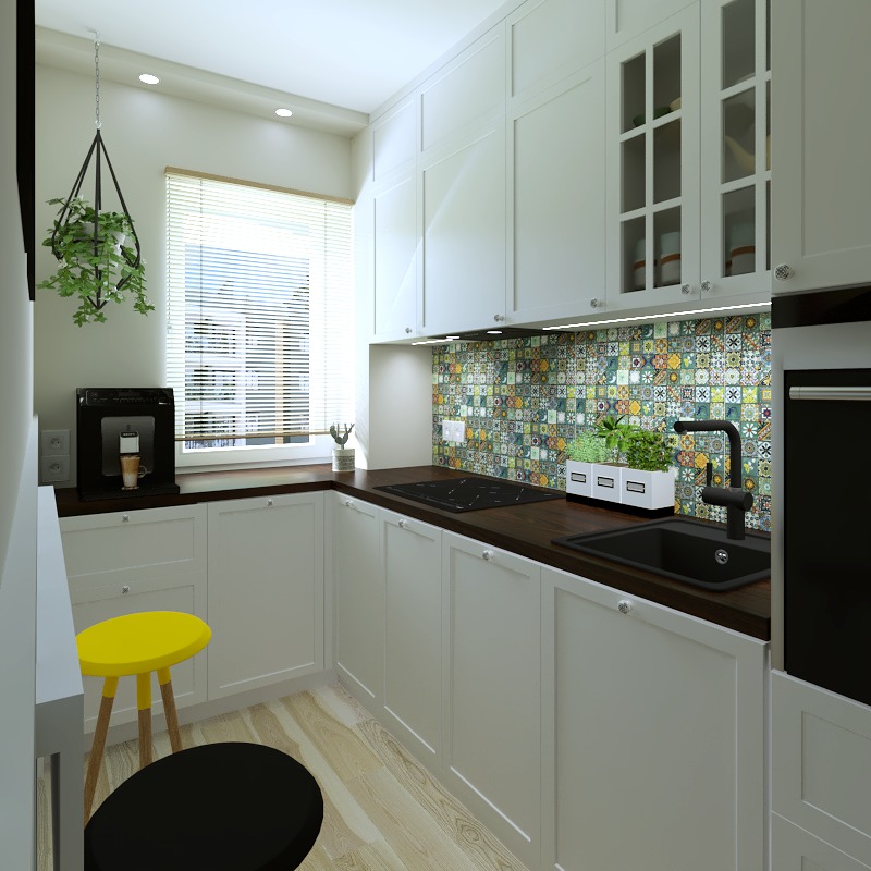 Jasna kuchnia z białymi szafkami, ciemnym blatem i kolorową mozaiką na ścianie, wisząca roślina i żółte krzesło barowe dodają akcentu.