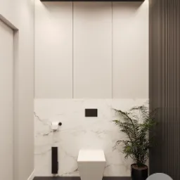 Nowoczesna łazienka z wiszącą toaletą na tle marmurowej ściany, obok roślina w czarnej donicy, minimalistyczny design z elementami drewna i oświetleniem LED.