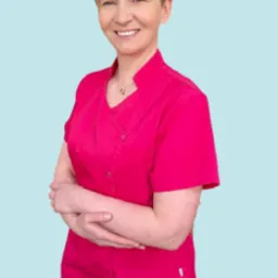 Uśmiechnięta kobieta w różowym uniformie medycznym, stojąca na jasnoniebieskim tle z motywem płatków śniegu.