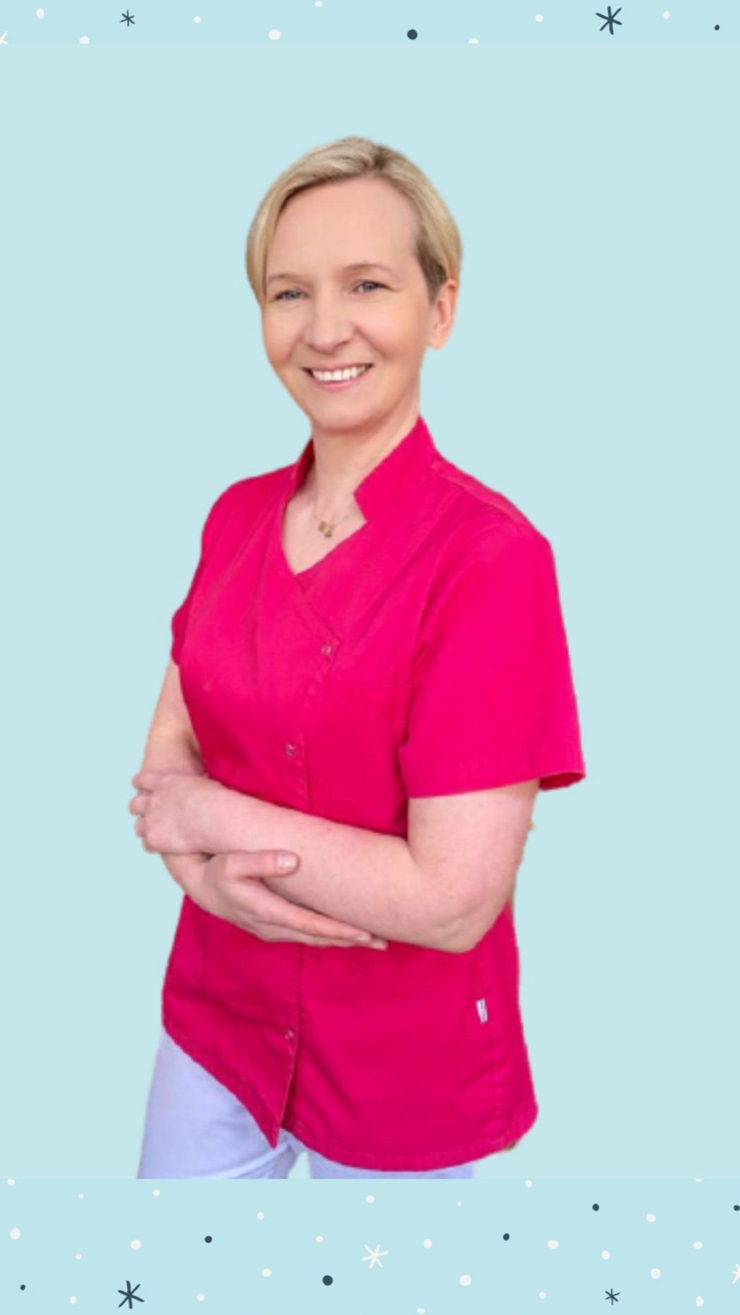 Uśmiechnięta kobieta w różowym uniformie medycznym, stojąca na jasnoniebieskim tle z motywem płatków śniegu.