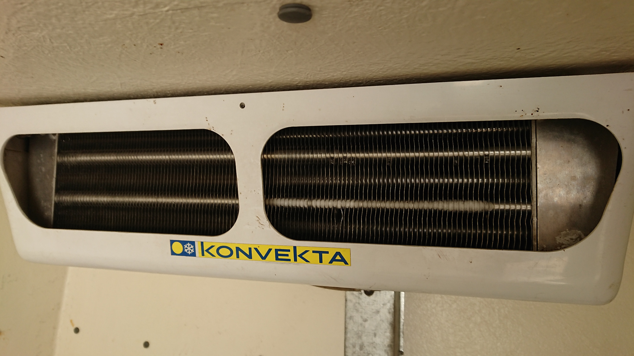 Wewnętrzny agregat chłodniczy Konvekta zamontowany w pojeździe dostawczym, widoczne żeberka chłodzące i logo producenta.