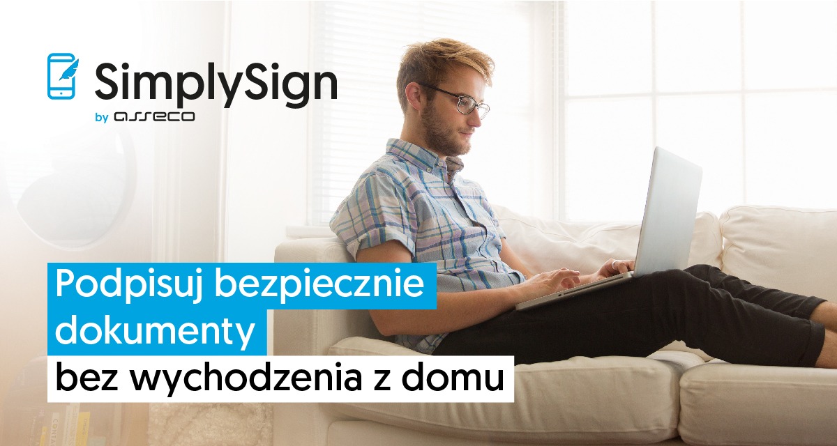 Mężczyzna w okularach siedzi na białej sofie z laptopem na kolanach, w tle okno. Reklama usługi podpisywania dokumentów online.