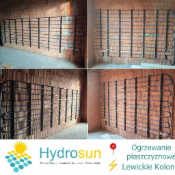 Montaż niebieskich rur ogrzewania podłogowego na ścianie z cegły dziurawki, widoczne uchwyty mocujące i fragmenty przewodów elektrycznych.