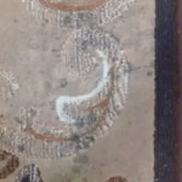 Fragment wzorzystej tapicerki z widocznym odbarwieniem po czyszczeniu, ukazujący skuteczność usuwania zabrudzeń.