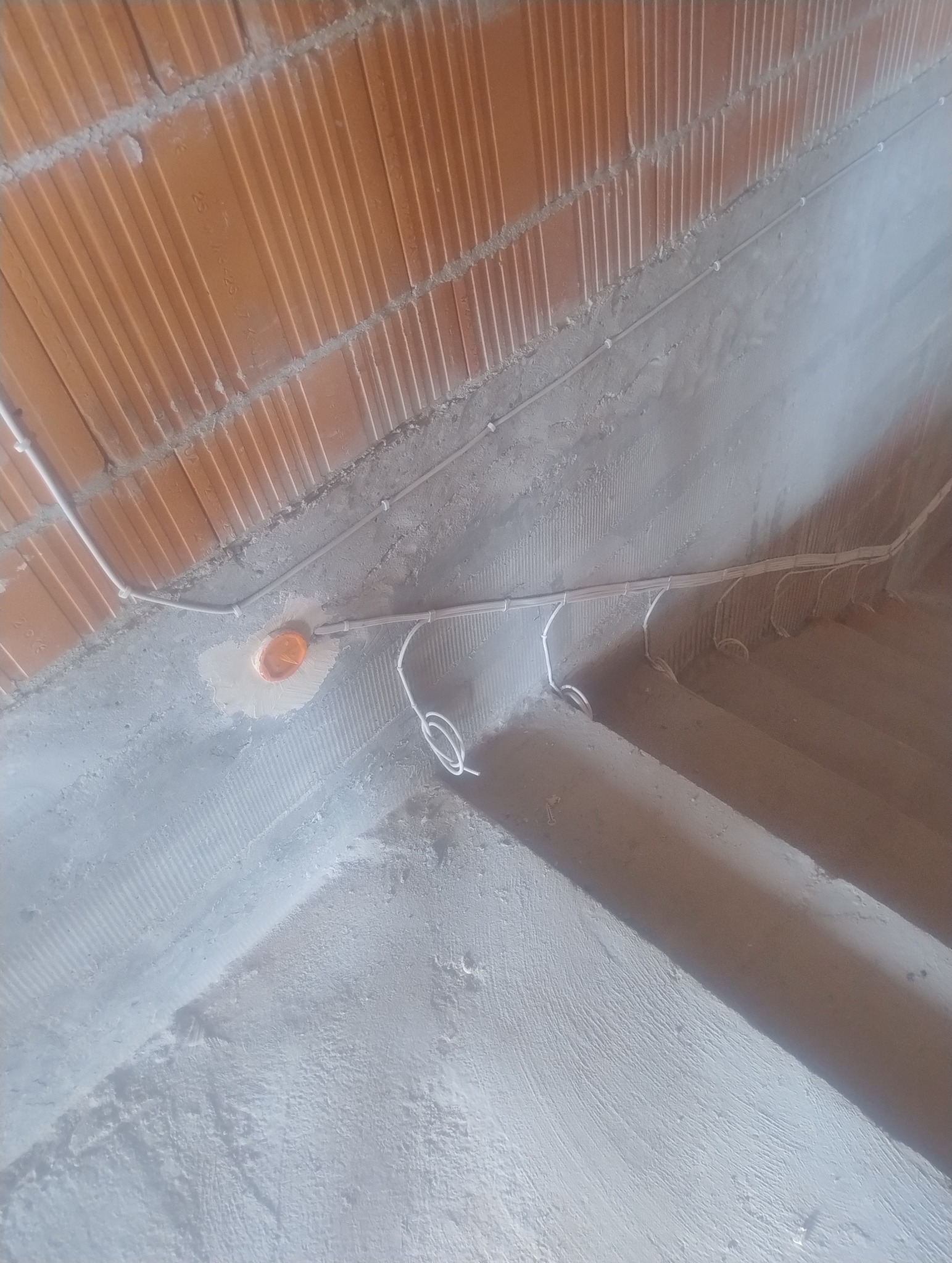 Instalacja elektryczna pod stropem Teriva: kable w peszlach prowadzone wzdłuż belek, widoczna puszka instalacyjna. Surowy stan, przygotowanie do dalszych prac.