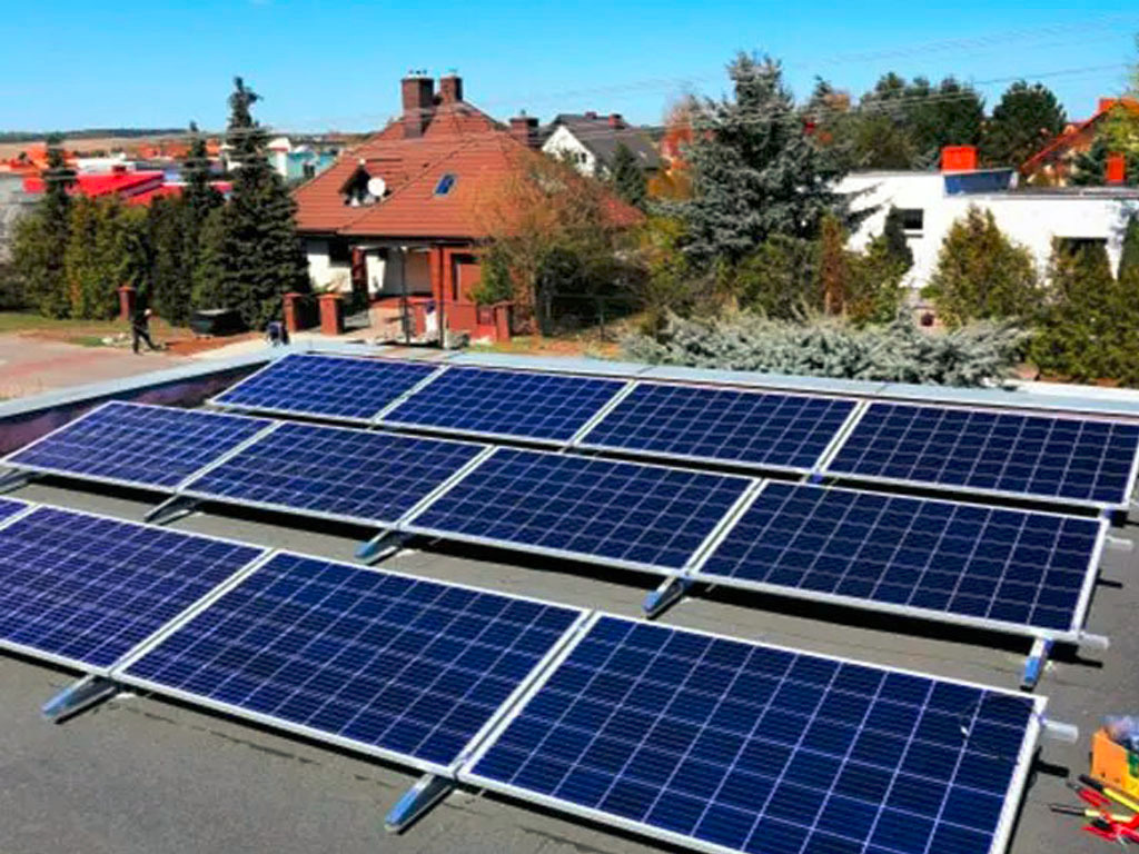 Instalacja paneli fotowoltaicznych na dachu budynku jednorodzinnego w słoneczny dzień. Widoczne narzędzia instalacyjne.