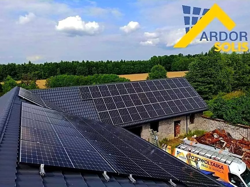 Instalacja paneli słonecznych na dachu domu jednorodzinnego z widocznym firmowym vanem z logo 'ARDOR SOLIS' i napisem 'FOTOWOLTAIKA PRĄD ZE SŁOŃCA' w tle.