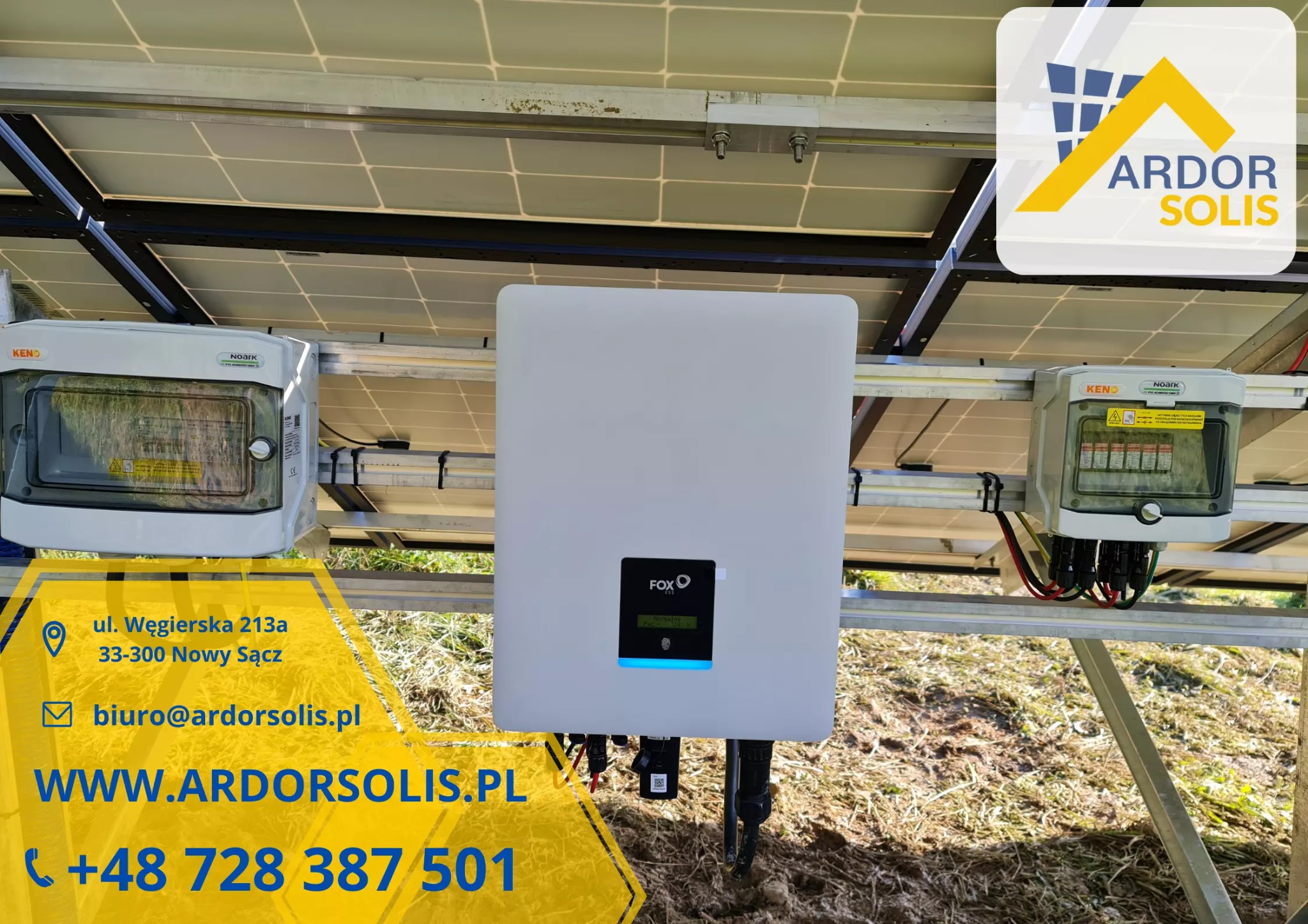 Widok z dołu na panele słoneczne, falownik FOX ESS i skrzynki KENO Noark, z widocznymi przewodami i elementami montażowymi, częściowo zasłonięty przez żółty baner reklamowy z danymi kontaktowymi...