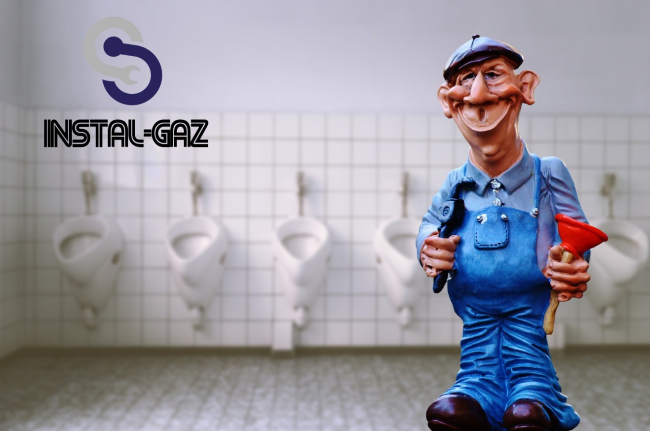 Karykaturalna figurka hydraulika w niebieskim kombinezonie, trzymająca klucz francuski i przepychaczkę, na tle rzędu pisuarów i logo firmy Instal-Gaz.