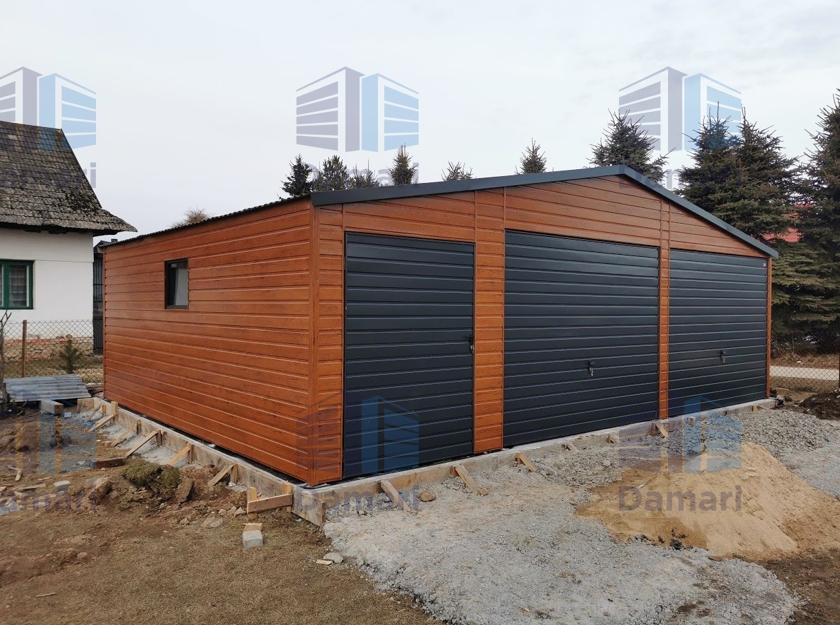 Dwustanowiskowy garaż blaszany z dodatkowym wejściem bocznym, wykończony imitacją drewna, na betonowej podmurówce w trakcie prac wykończeniowych terenu.