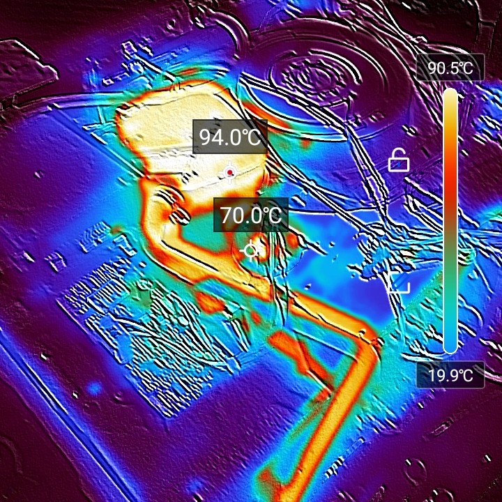Termowizja wnętrza urządzenia AGD, ukazująca rozkład temperatur wewnątrz. Widoczne elementy elektroniczne i przewody w spektrum barw od niebieskiego do pomarańczowego.