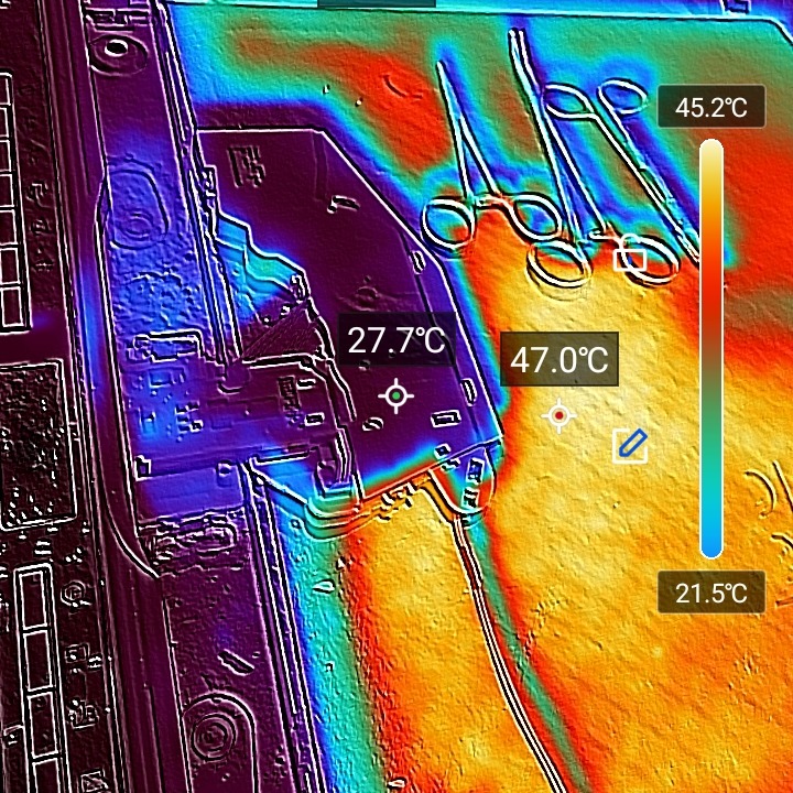 Termowizja wnętrza zmywarki z narzędziami, ukazująca rozkład temperatur podczas pracy. Widoczne szczypce i pomiary temperatury w stopniach Celsjusza.