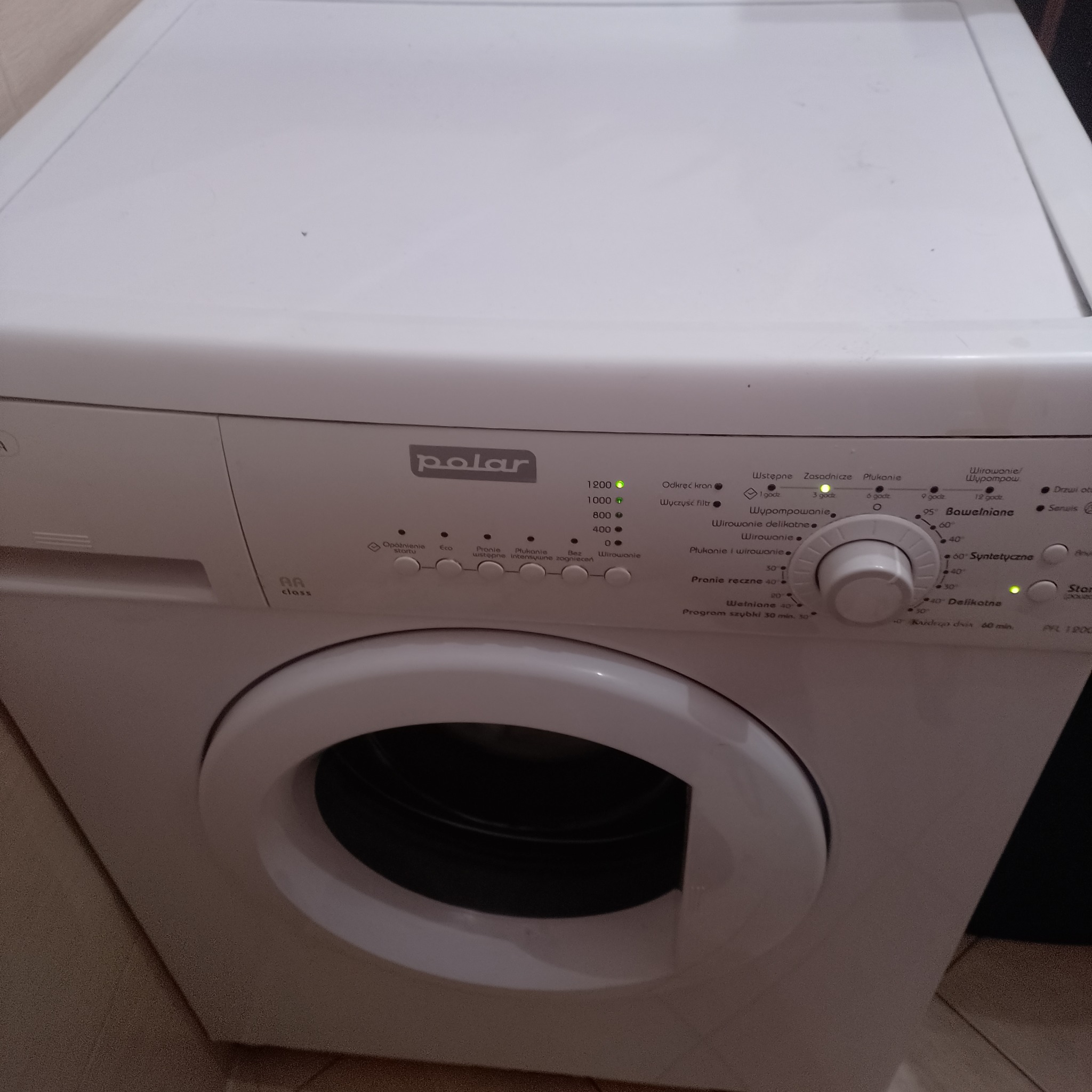 Biała pralka Polar z panelem sterowania, widoczne diody i pokrętło wyboru programu. Usługi naprawy pralek w Krakowie. Sprzęt AGD w zbliżeniu.