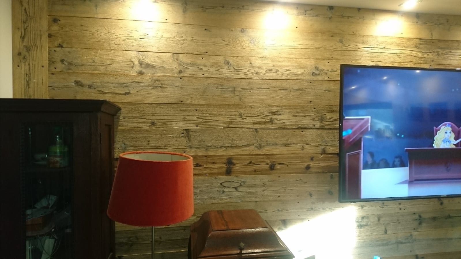 Zabudowa ściany w salonie ze starych desek sosnowych.