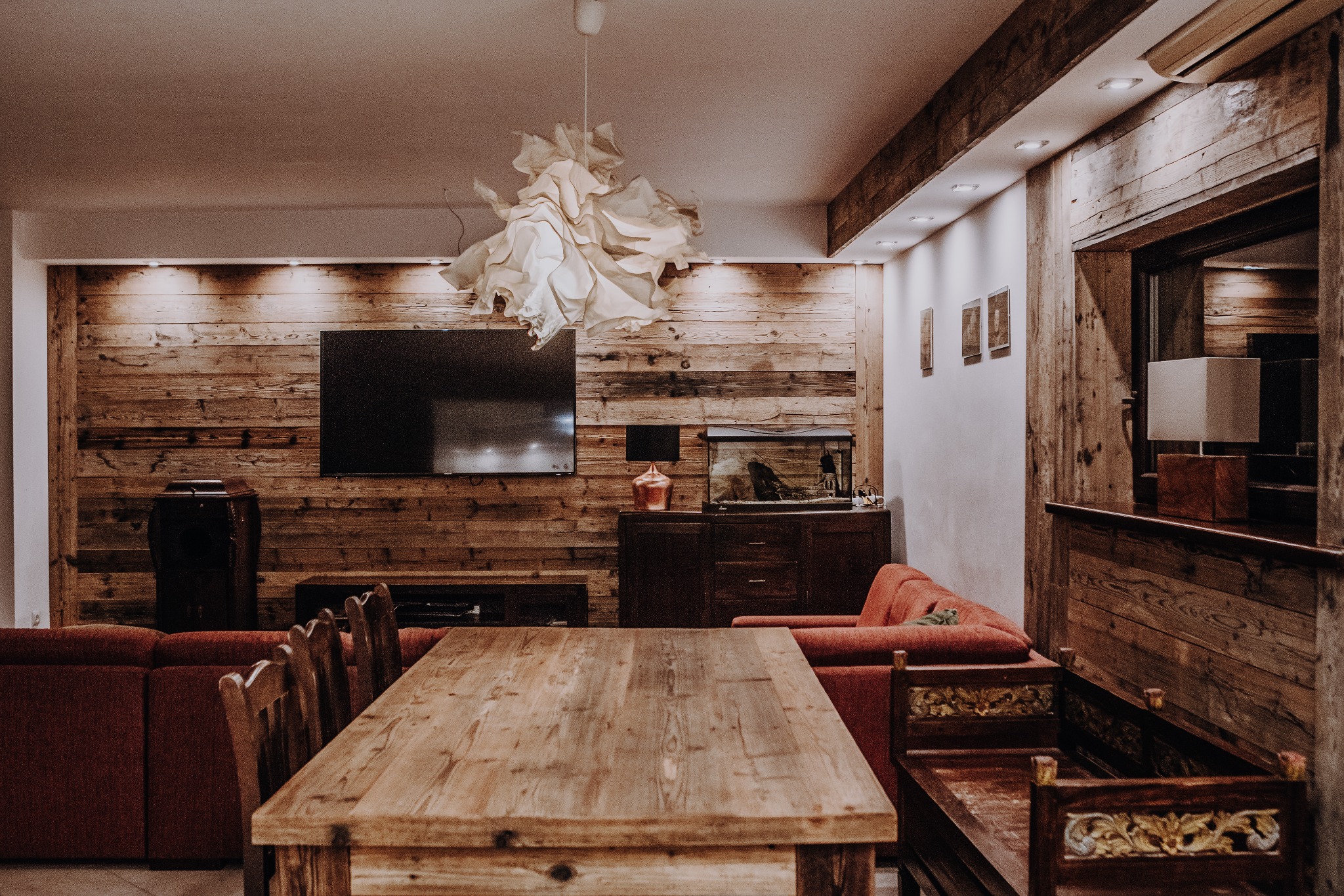 Kompleksowe wykończenie salonu: zabudowy, stół, kinkiety.