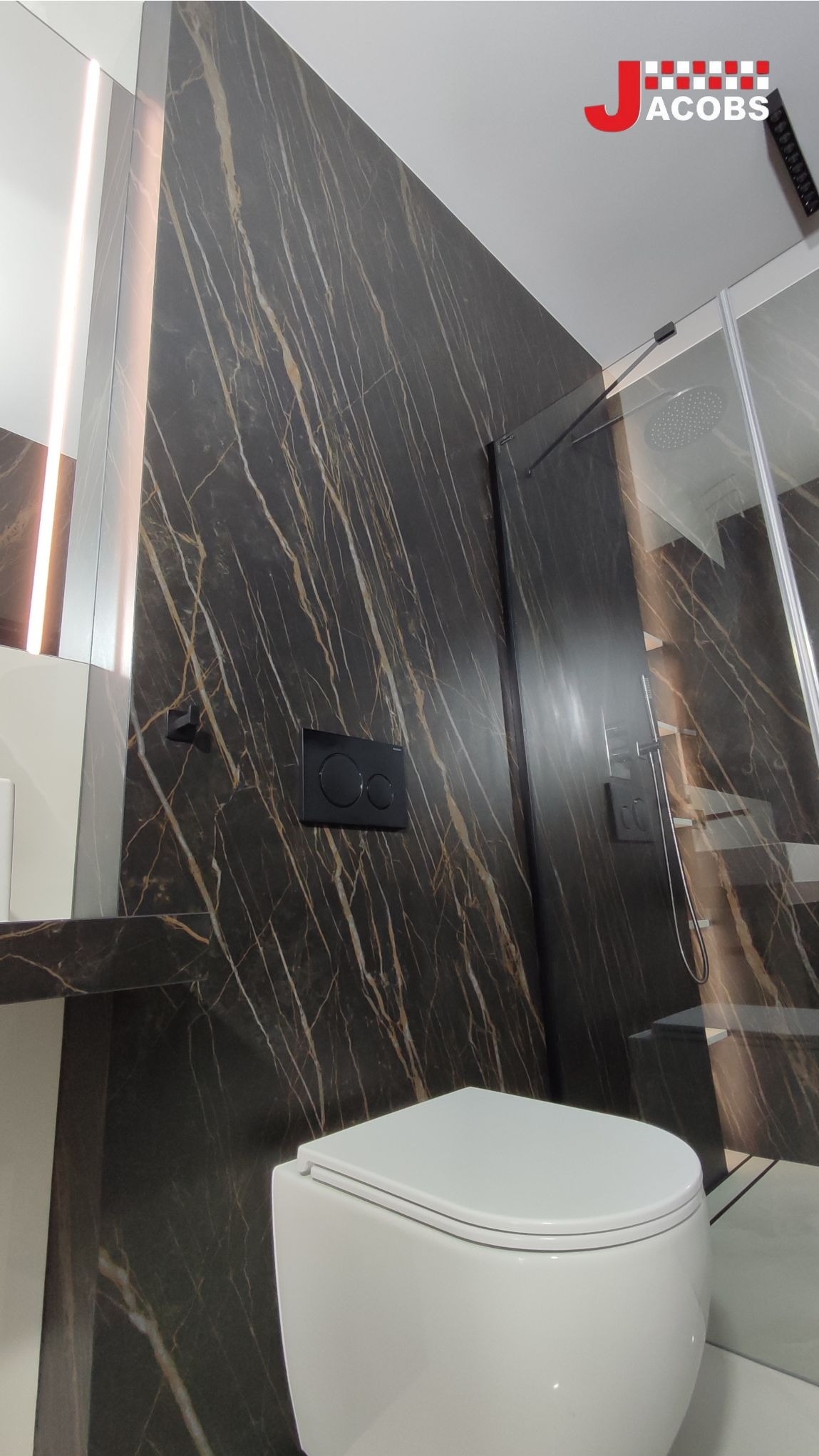 Elegancka łazienka w Lalikach z marmurową ścianą i podwieszaną toaletą. Kabina prysznicowa ze szklanymi drzwiami. Nowoczesny design.