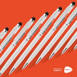 Rząd białych długopisów z rysikiem i nadrukowanym adresem strony internetowej na pomarańczowym tle, ułożonych ukośnie od najmniejszego do największego.