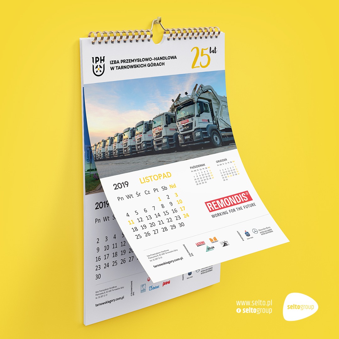 Kalendarz ścienny z widokiem floty samochodów ciężarowych na tle błękitnego nieba, z zaznaczonym miesiącem listopadem 2019 roku.