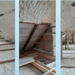 Poddasze ocieplone pianą poliuretanową, widoczne krokwie i elementy konstrukcyjne dachu, biała izolacja pokrywa ściany i podłogę, fragment komina w centralnej części.