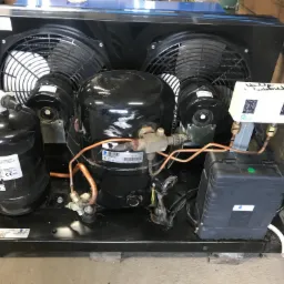 Agregat chłodniczy z dwoma wentylatorami i czarną obudową, widoczne elementy instalacji miedzianej, zbiornik czynnika chłodniczego Culobel i skrzynka elektryczna z zieloną diodą.