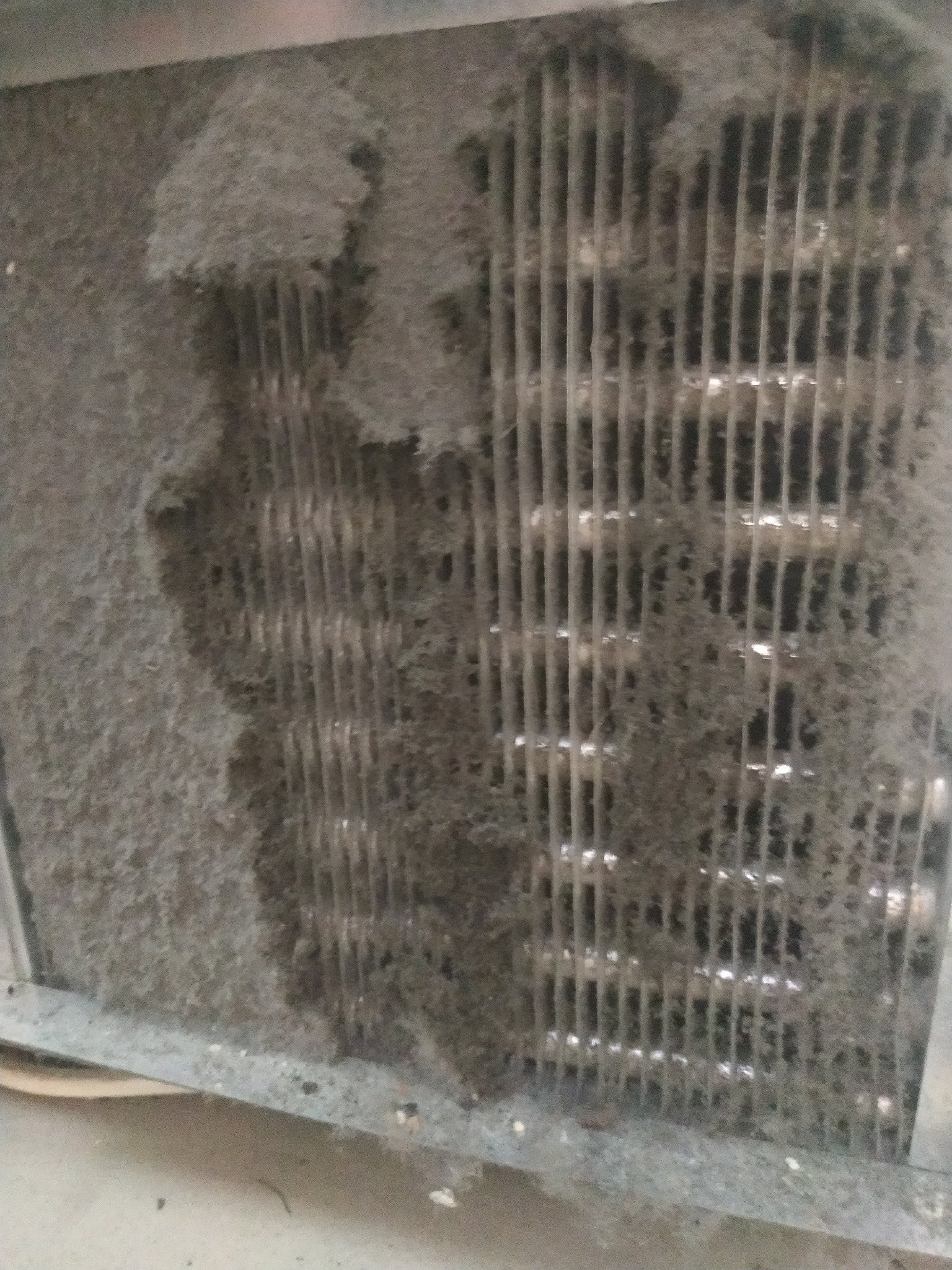 Zanieczyszczony, zakurzony filtr klimatyzacji z widocznymi lamelami, wymagający pilnego czyszczenia.