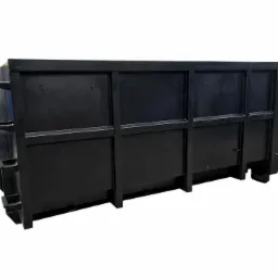 Pusty, czarny kontener stalowy na odpady budowlane, widok z boku, na białym tle.