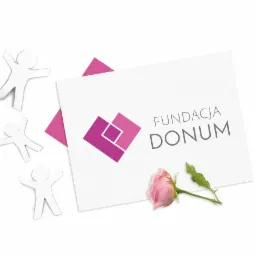 Karta z fioletowym logo Fundacji Donum, ozdobiona różową różą i papierowymi figurkami ludzi na białym tle.