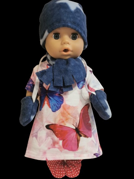 Lalka w komplecie ubranek: sukienka w motyle, spodnie w kropki, czapka, szalik i rękawiczki z niebieskiego polaru.