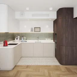 Nowoczesna kuchnia z zaokrąglonymi szafkami w kolorze kremowym i ciemnego drewna, zielone płytki nad blatem, czerwony czajnik i roślina doniczkowa w lewym dolnym rogu.