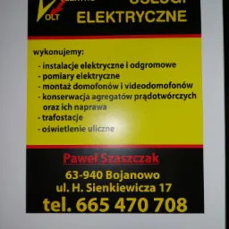Tablica informacyjna firmy Elektro OLT oferującej usługi elektryczne, w tym instalacje, pomiary, montaż domofonów, konserwację agregatów prądotwórczych, trafostacje i oświetlenie uliczne. Zawiera...