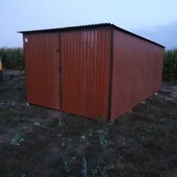 Korona - Brązowy, blaszany garaż gospodarczy z dwuskrzydłowymi drzwiami, ustawiony na nieużytku z chwastami, z polem kukurydzy w tle, sfotografowany o zmierzchu.