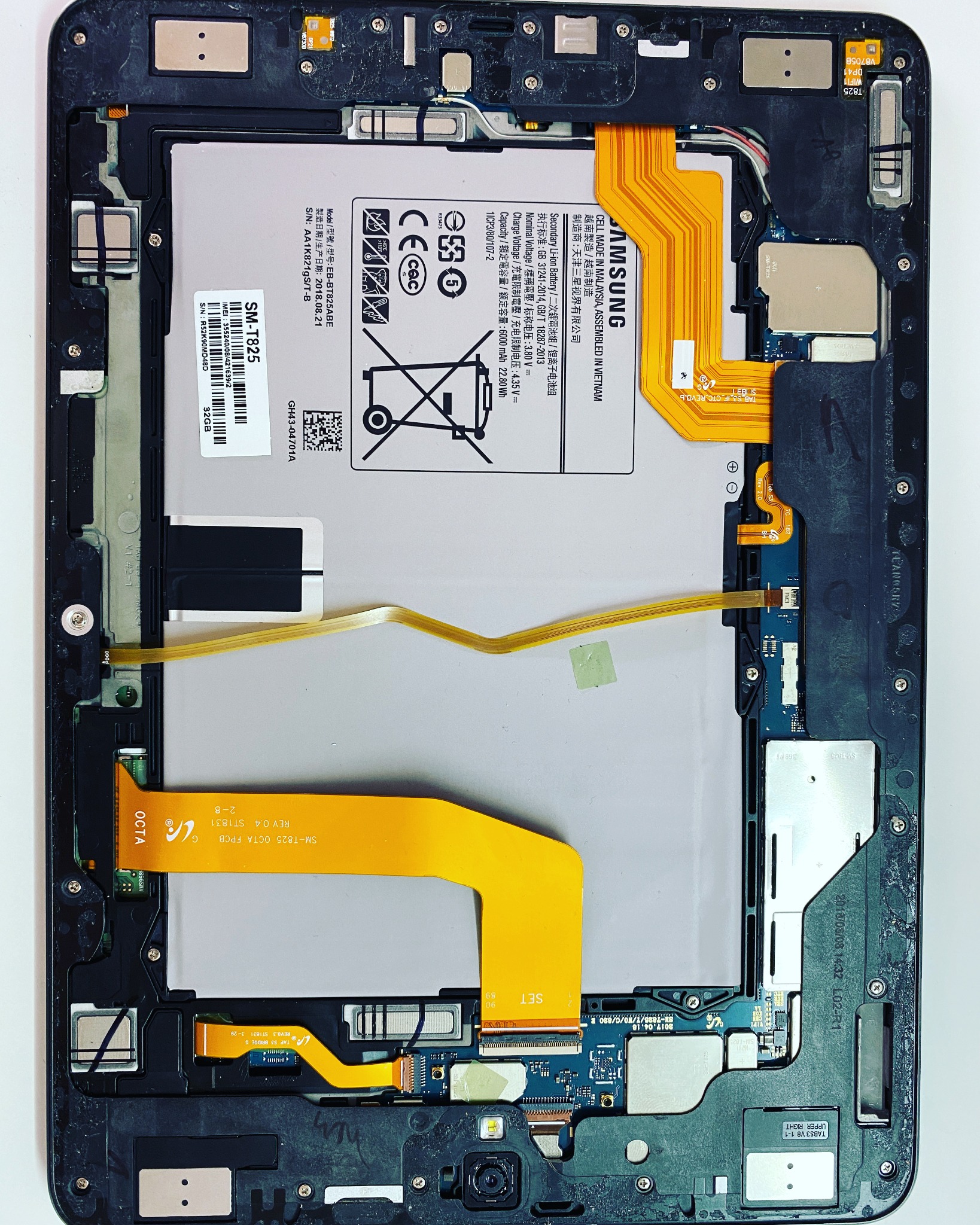 Wnętrze tabletu Samsung Galaxy Tab S3 (SM-T825) po demontażu obudowy, widoczna bateria, płyta główna i liczne złącza taśmowe.