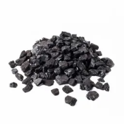 Kupa czarnego ekogroszku o nieregularnych kształtach na białym tle, z widocznymi refleksami światła na powierzchni bryłek.