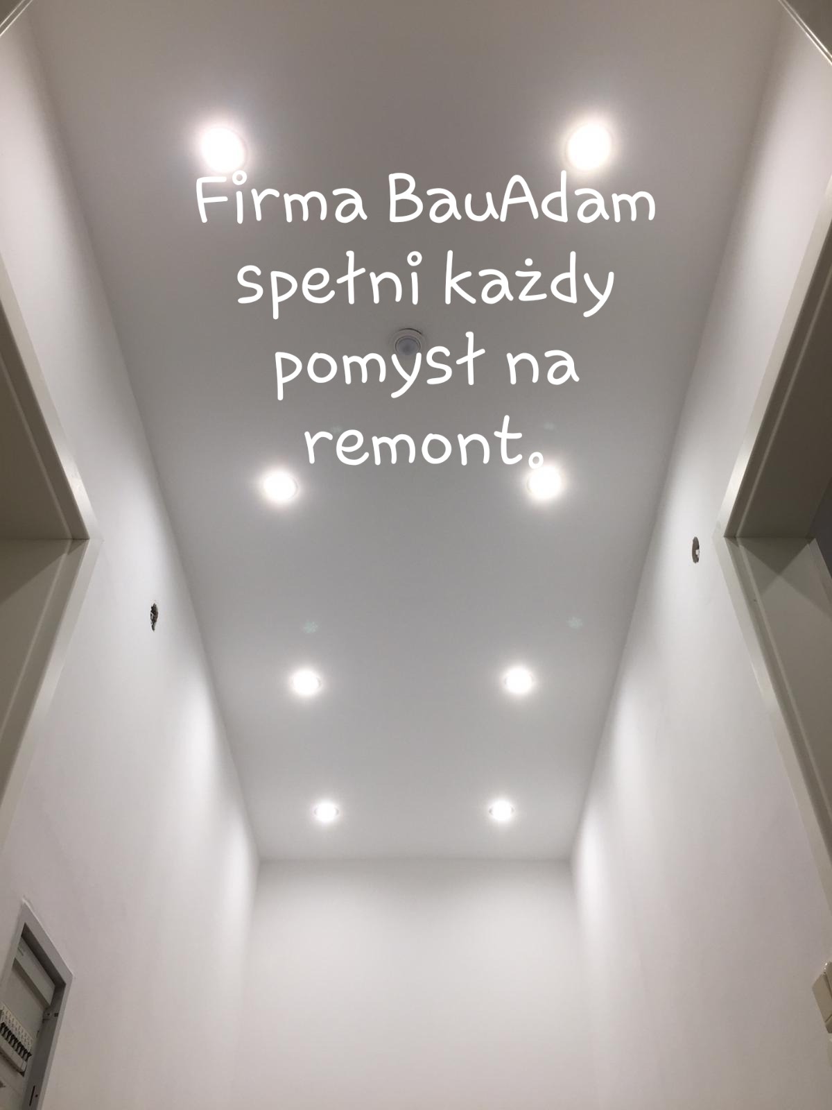Biały sufit z wpuszczonymi punktowymi lampami LED, świeżo po remoncie, widoczne fragmenty ścian i futryn drzwi, napis 'Firma BauAdam spełni każdy pomysł na remont'.