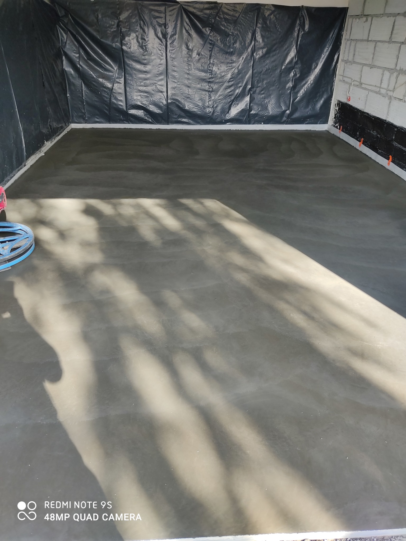 Wylana, świeża posadzka jastrychowa w pomieszczeniu przygotowanym do dalszych prac wykończeniowych w Lubichowie, z widocznym fragmentem maszyny do zacierania.