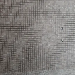 Ściana i podłoga wyłożone mozaiką z małych, kwadratowych płytek w odcieniach szarości z delikatnym marmurkowym wzorem; widoczne dwa otwory montażowe.