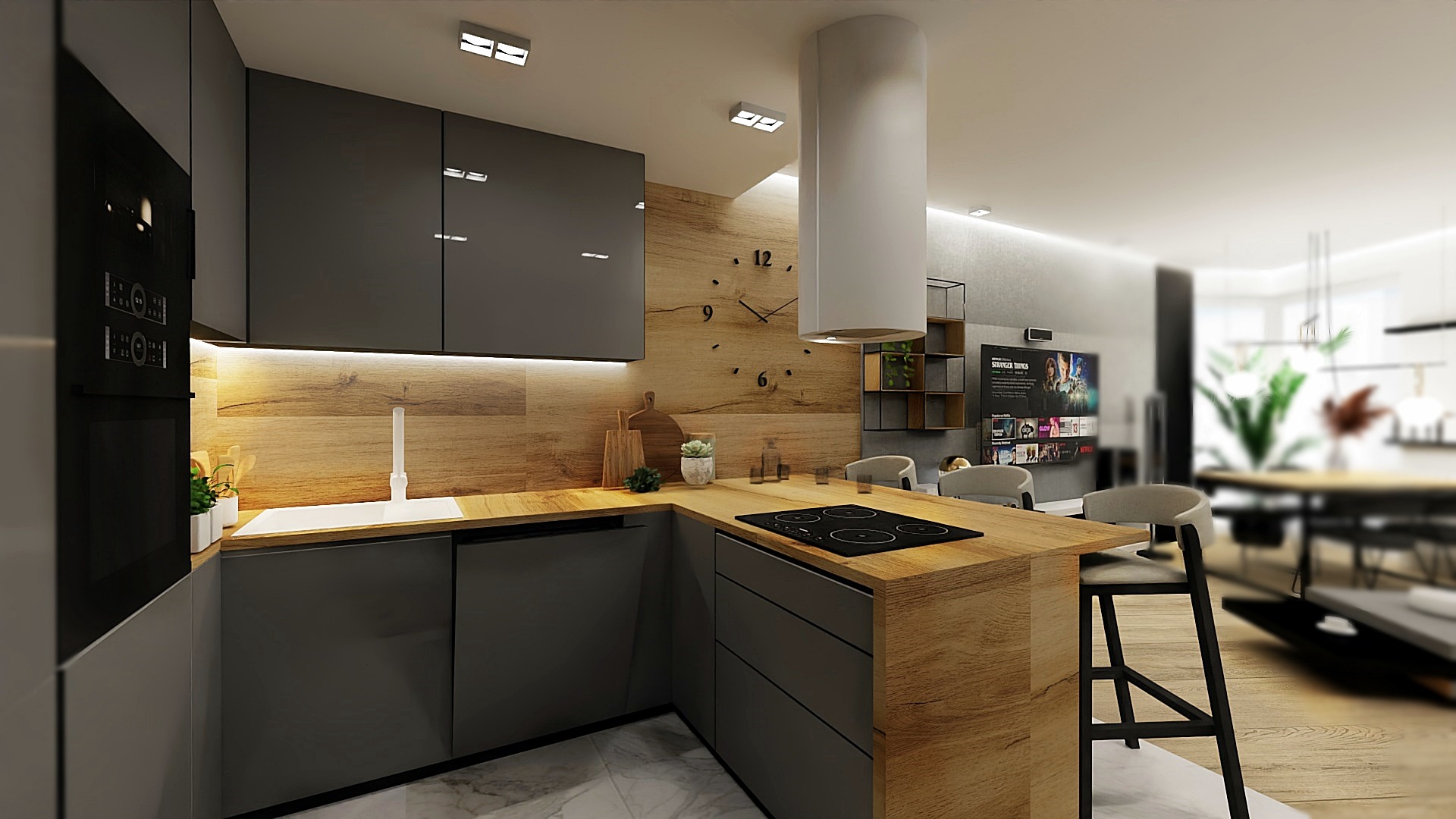 Nowoczesna kuchnia z szarymi szafkami, drewnianym blatem i panelem ściennym, okrągłym zegarem na ścianie i białym okapem cylindrycznym, otwarta na salon z telewizorem.