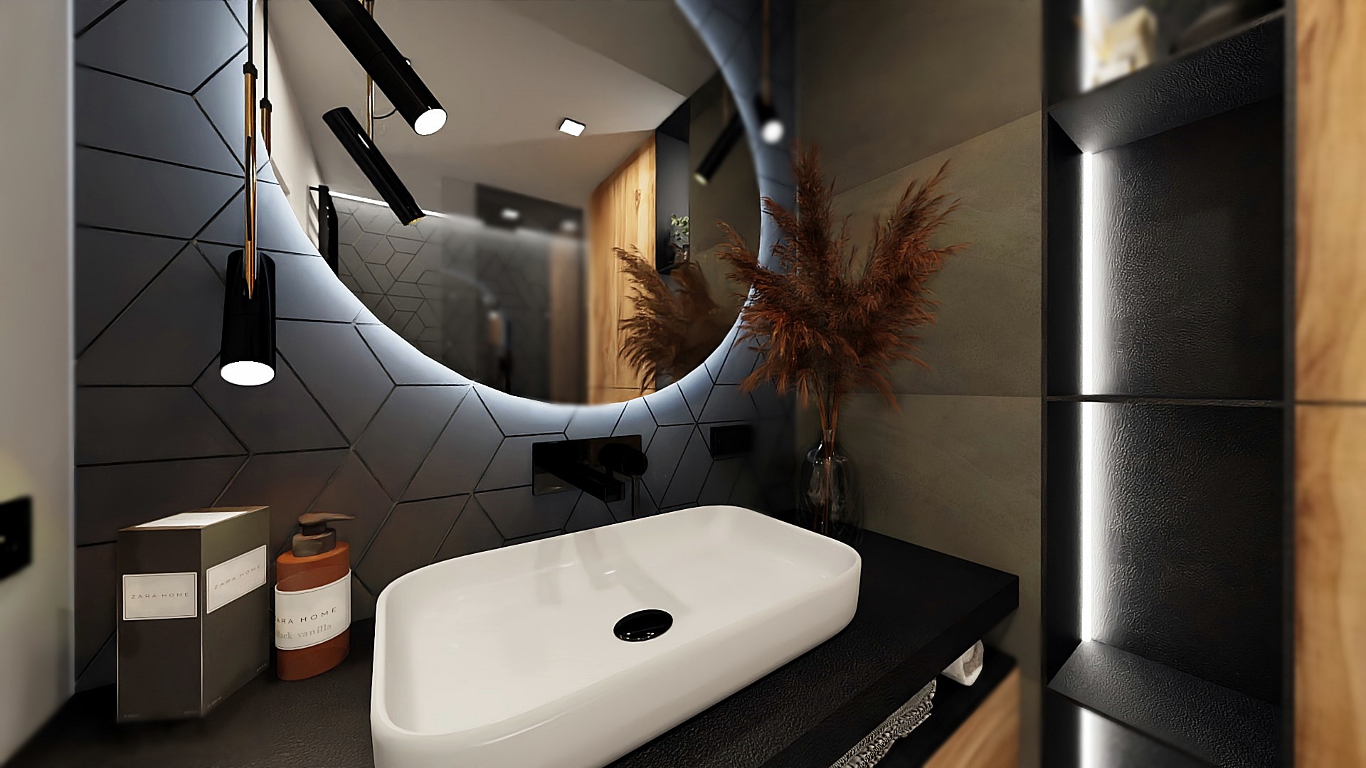 Nowoczesna łazienka w Krakowie z umywalką nablatową, okrągłym lustrem z podświetleniem LED i geometryczną ścianą z płytek w odcieniach szarości oraz dekoracyjną trawą pampasową w wazonie.