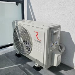 Eko-KlimaWent Bobowicz - Zewnętrzna jednostka klimatyzacji Rotenso zamontowana na balkonie, widoczna z boku, z szarymi płytkami podłogowymi i białą ścianą w tle.