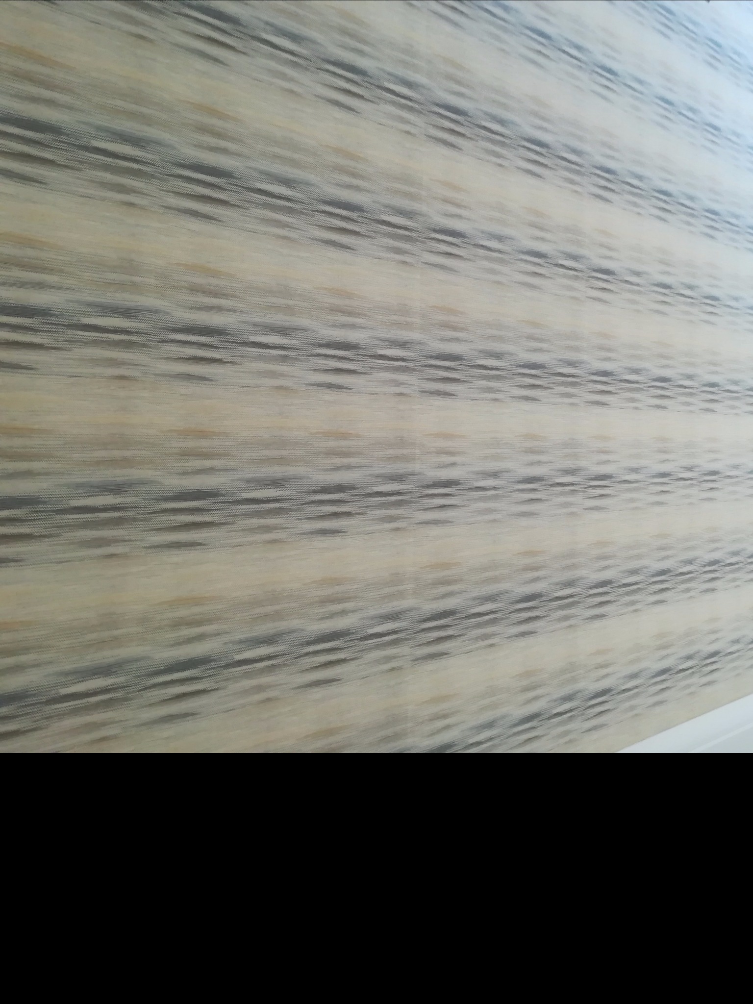 Wzorzysta ściana w odcieniach beżu i szarości, świeżo po nałożeniu gładzi w Świętochłowicach, z widoczną delikatną strukturą.