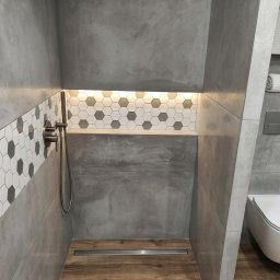 ANATOLII - Nowoczesna łazienka z szarą armaturą, heksagonalnymi płytkami i drewnianą podłogą. Kabina prysznicowa typu walk-in z odpływem liniowym. Minimalistyczny design.