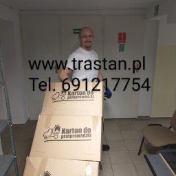 Marcin Stańczyk podczas transportu kartonów za pomocą wózka trastan