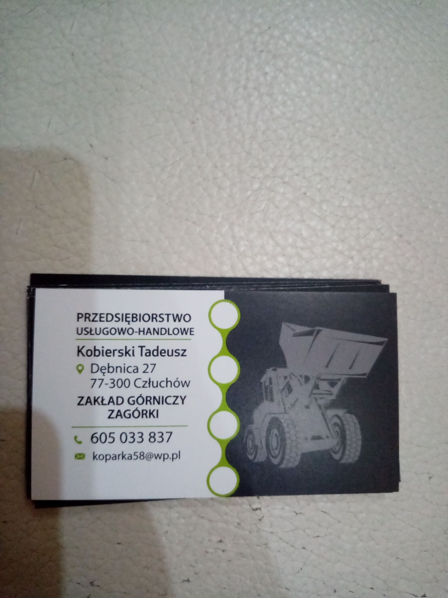 Wizytówka firmy Kobierski Tadeusz z ilustracją wywrotki, oferującej usługi górnicze i handlowe, z adresem w Dębnicy i numerem telefonu 605 033 837.