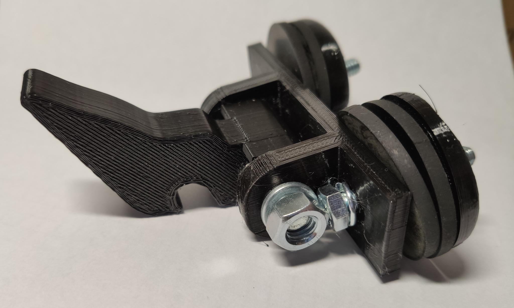 Czarny, trójwymiarowy wydruk z widocznymi warstwami, połączony śrubami i nakrętkami, prawdopodobnie element maszyny.