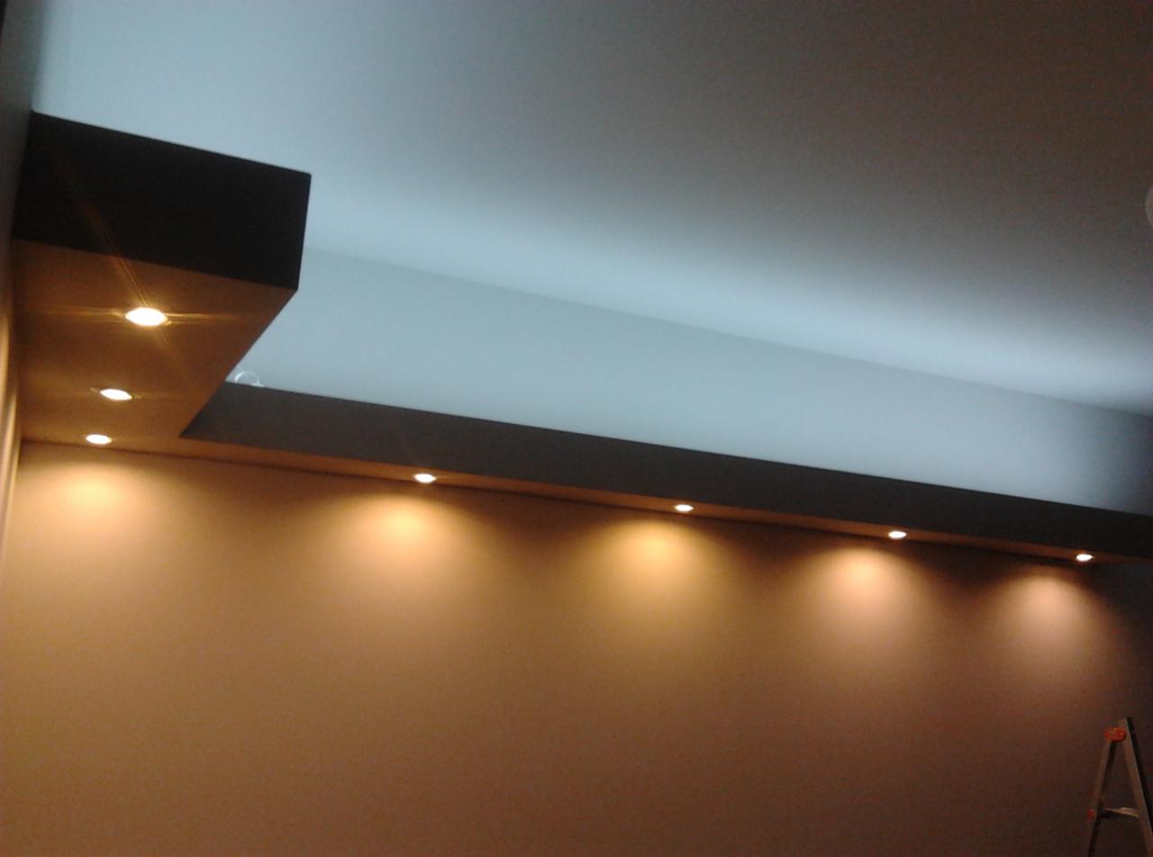 Oświetlenie sufitowe z wbudowanymi punktowymi lampami LED, brązowa ściana, drabina w rogu, widok od dołu.