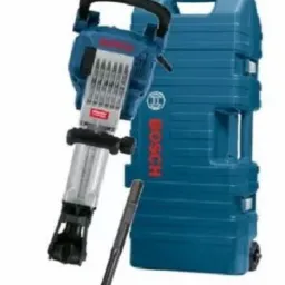 Młot wyburzeniowy marki Bosch w kolorze niebieskim, wraz z dłutem i walizką transportową na kółkach.