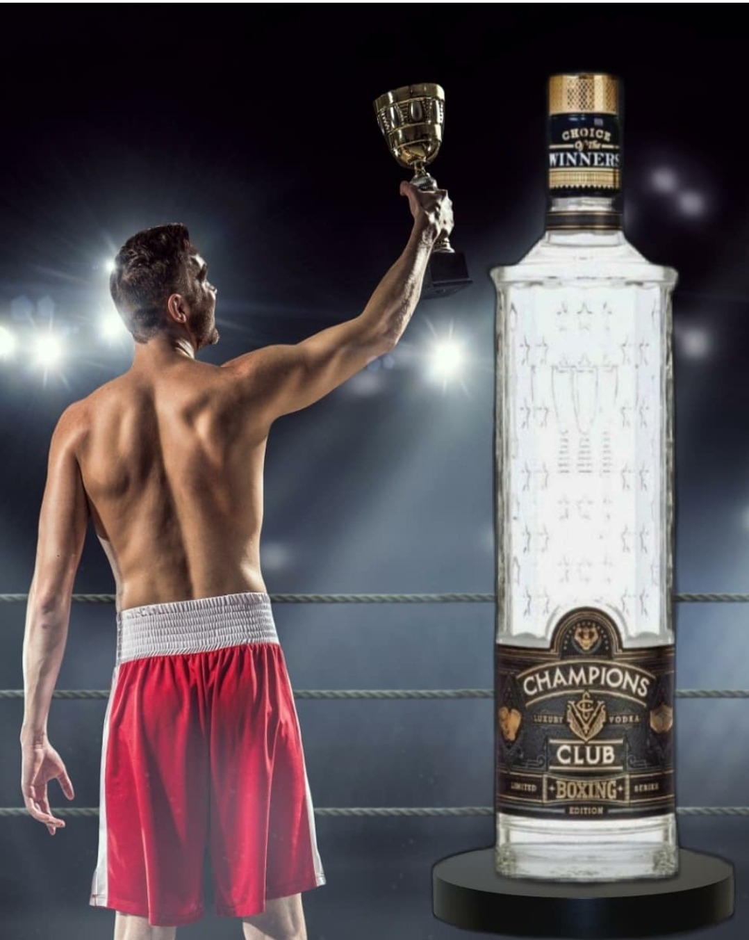 Bokser z nagrodą i butelką wódki 'Champions Club Boxing Edition' na tle ringu.