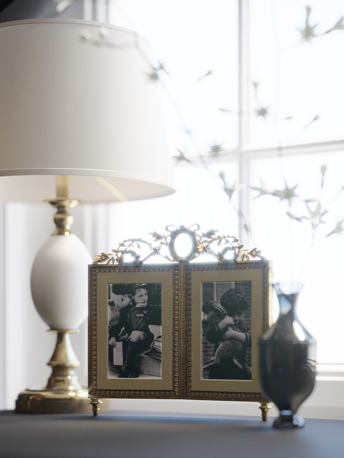 Stylowa, złota ramka na zdjęcia z dwoma czarno-białymi fotografiami dzieci, ustawiona obok lampy z białym abażurem i ciemnego wazonu na tle okna.