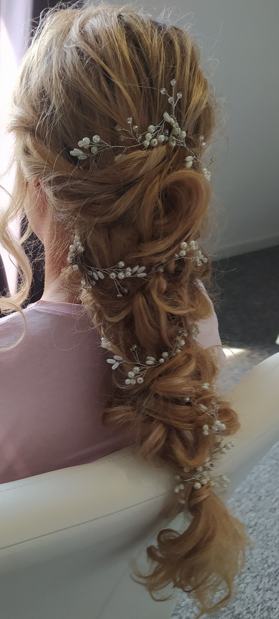 Upięcie blond włosów w warkocz z ozdobnymi spinkami z perełkami i kryształkami, widok z tyłu.